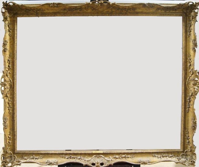 A Gilded Composition Louis XV Style Swept and Pierced Frame, early-mid 20th century, with cavetto and stiff leaf sight, the plain ogee with foliate and flower head scrollwork, shell cartouche centres and corners dentil back edge, 101 x 121.5 cm...