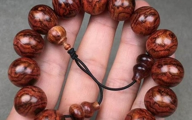 A HUANGHUALI WOOD STRING BRACELET WITH 14 BEADS