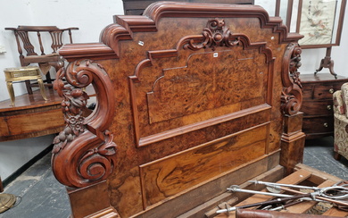 A LATE VICTORIAN BURR WALNUT DOUBLE BED WITH PANELLED ENDS FLANKED BY SCROLLING BRACKETS CARVED WITH