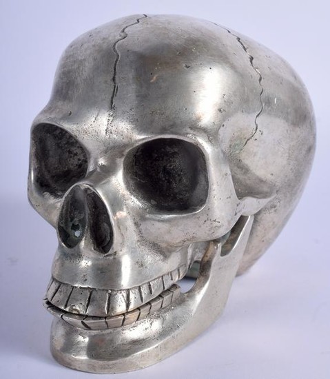 A SILVER PLATED SCULPTURE OF A SKULL. 10.5 cm x 12 cm.