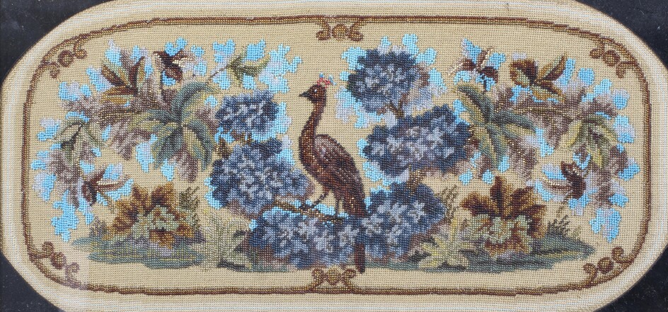 A Victorian beadwork and woolwork panel, woven with a bird amongst flowers and foliage, framed