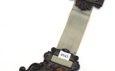 A WATERBURY WALL CLOCK WITH AN ORNATELY CARVED AND PAINTED OAK BODY, SUSPENDED FROM A RIBBON, 37 CM HIGH