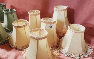 A collection of 7 small clip on lamp shades.