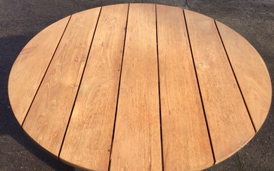 A contemporary hardwood circular dining table with planked top in...