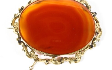 A late 19th century unmarked yellow metal brooch with oval set orange agate of oval form