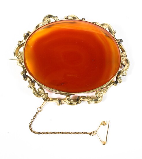 A late 19th century unmarked yellow metal brooch with oval set orange agate of oval form