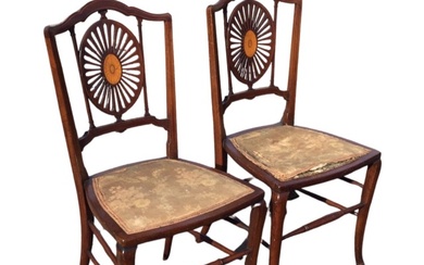 A pair of Edwardian mahogany chairs with shaped backs above...