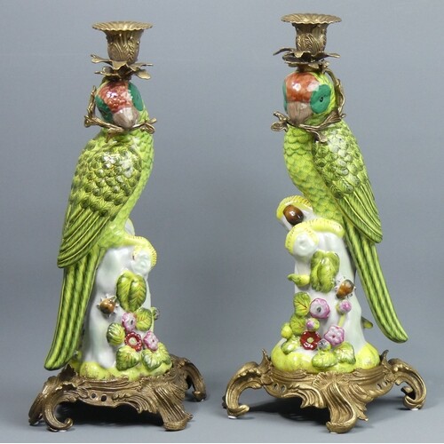 A pair of bronze and porcelain parrot design large candlesti...