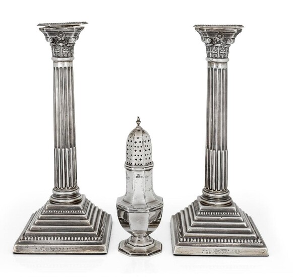 A pair of silver Corinthian column candlesticks, Birmingham, 1968, LD Ltd., raised on stepped square bases, filled 31cm high, together with a silver sugar caster, Sheffield, 1931, Viners Ltd., of hexagonal baluster form 18.2cm high, weighable...