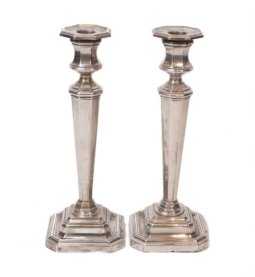 A pair of silver candlesticks, Sheffield, c. 1926 and 1928, James Dixon & Sons, the tapering, faceted stems to stepped square bases and fixed octagonal capitals, 26cm high, filled (pr)