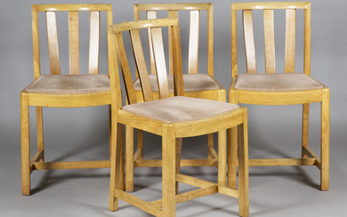 A set of four early 20th century Heals pale oak comb back dining chairs with drop-in seats, bearing