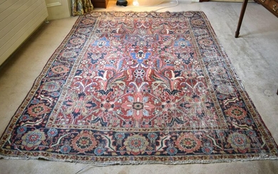 AN ANTIQUE MIDDLE EASTERN CARPET decorated with