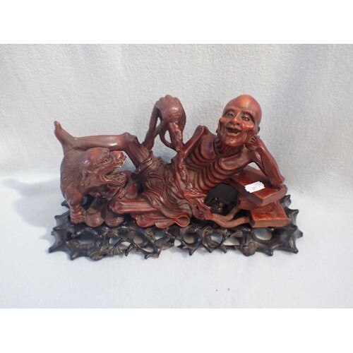 AN ASIAN WOODEN STATUE OF EMACIATED FIGURE WITH STAND