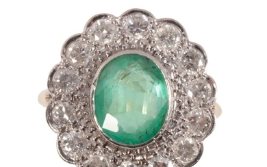 AN EMERALD AND DIAMOND CLUSTER RING the oval-cut emerald, c....
