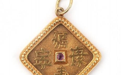 A 14 karat gold pendant with Chinese characters. Featuring a faceted ruby in the center at the front and backside. Gross weight: 6 g.