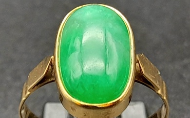 An 18K Yellow Gold Jade Ring. Green jade oval cabochon. Size...