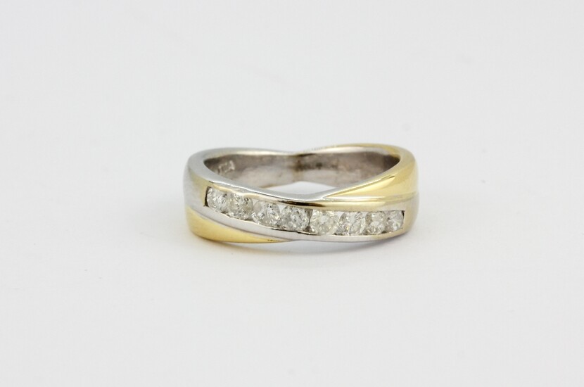 An 18ct yellow and white gold diamond set crossover ring, approx. 0.50ct, approx. 6.7gr, (M).