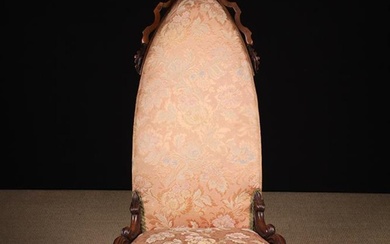 An Unusual, Gothic Revival, Upholstered Victorian Nursing Chair covered in floral woven pink fabric.