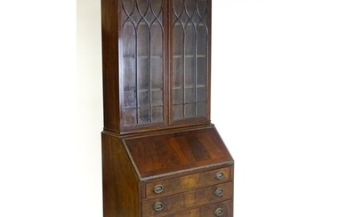 An early 20thC mahogany bureau bookcase with a carved cornic...