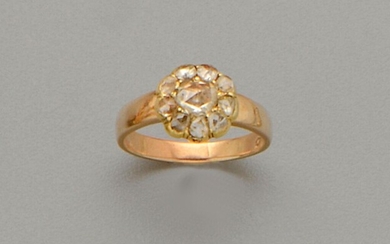 Bague ancienne en or jaune 18K (750/oo) centrée d'un motif Marguerite serti d'un diamant taillé...