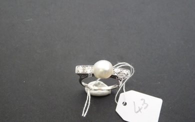 Bague en or gris 18K (750/oo) centrée d'une perle fine bouton épaulée par quatre diamants...