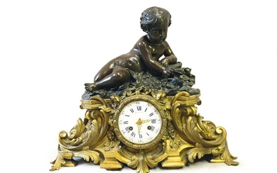 Bronze clock featuring a patinated putto on a gilded rocaille base, the dial signed Raingo Frères. Numbered 559. (Accident to the glass).