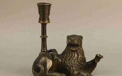 Candelabra in patinated bronze in the shape of a lying lion, the torch resting on its back. Old Flemish work. Height : 17 cm