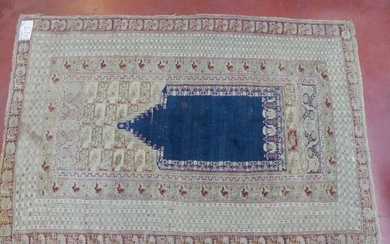 Handmade wool prayer mat decorated with a blue "Mihrab" on...