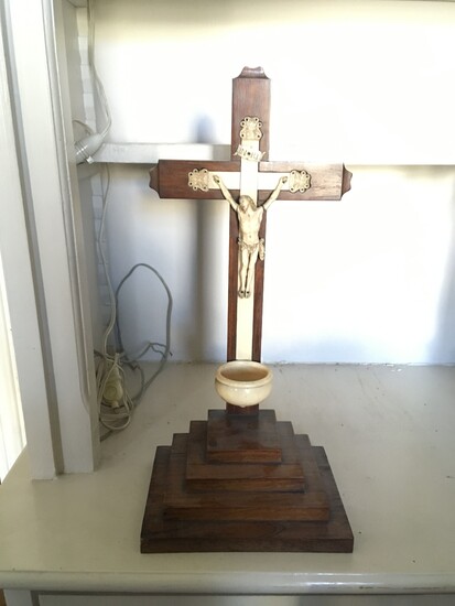Crucifix en ivoire formant bénitier sur socle à gradins en bois