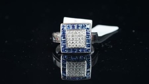 NEW OLD STOCK, Sapphire and Diamond ring, central square of diamonds, outer border of tension set sapphires, mounted in 14ct...