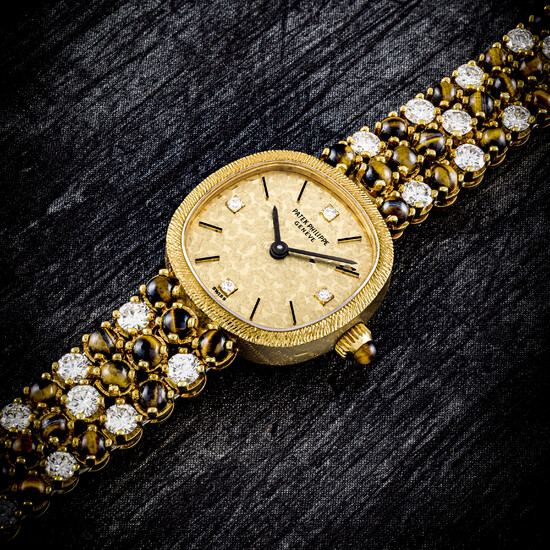 PATEK PHILIPPE. A LADY’S UNUSUAL 18K GOLD, DIAMOND AND TIGER’S EYE-SET BRACELET WATCH REF. 4009/1, MANUFACTURED IN 1977
