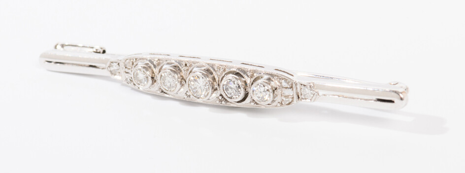 WHITE GOLD AND DIAMOND BAR PIN. Bright-polished bar centers row...