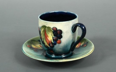 A Moorcroft Leaves and Berries coffee can and saucer
