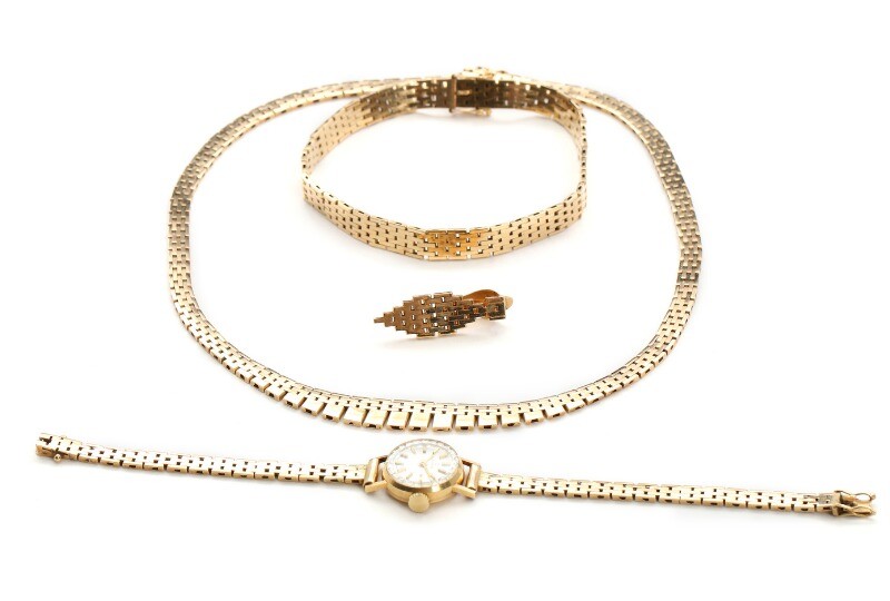 A 14k gold jewellery set, comprising necklace, bracelet and single ear clip. L. 39.5, 20 and 2.8 cm. And a 14k gold lady's wristwatch. L. 17 cm. (4)