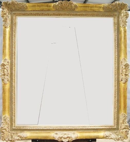 A Carved and Gilded Régence Style Frame, 20th century, with leaf ogee sight, sanded frieze, the plain ogee with foliate shell and cartouche centres and corners, schematic demi-fleur back edge, added white painted slip, 102.5 x 92.5 cm (sight)