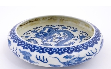 A Chinese blue and white dish decorated with dragons amidst ...