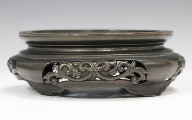 A Chinese bronze circular stand, 19th century, with pierced scrollwork sides, the top with incised k