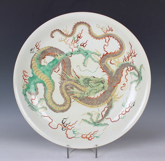 A Chinese famille verte porcelain circular dish, late Qing dynasty, painted with a dragon amidst vap