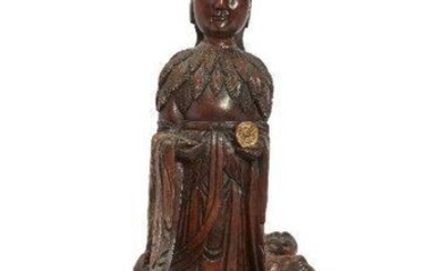 A Chinese gilt-painted rootwood carving of Guanyin, 20th century, carved standing atop a large naturalistic base, holding a fly whisk in right hand and a Taoist plaque in her left, both painted in gilt, 80cm high 二十世紀 癭木雕描金觀音立像