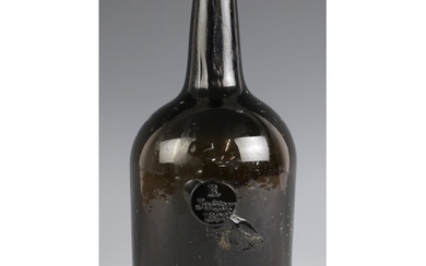A George III brown glass wine bottle, early 19th century, of...