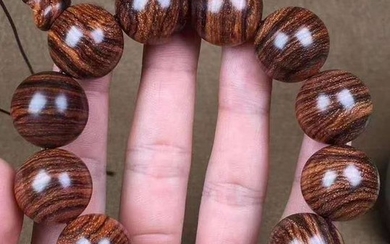 A HUANGHUALI WOOD STRING BRACELET WITH 12 BEADS