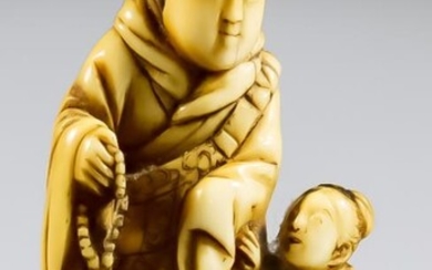 A Japanese Carved Ivory Netsuke of a Priest and...