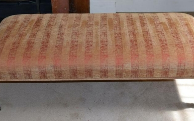 A LONG UPHOLSTERED RED AND GOLD GROUND OTTOMAN. 146 cm