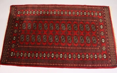 A MODERN BOKHARA STYLE RUG, red ground with two rows of
