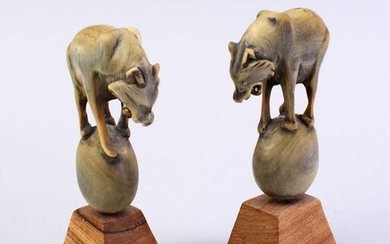 A PAIR OF CARVED HORN WOLF FIGURES, stood on balls