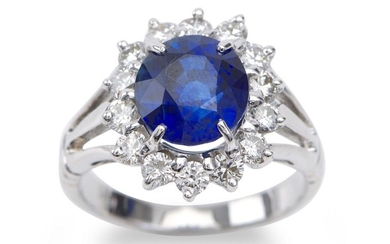 A SAPPHIRE AND DIAMOND RING - Featuring an oval sapphire weighing 4.45cts, within a border of round brilliant cut diamonds totalling...