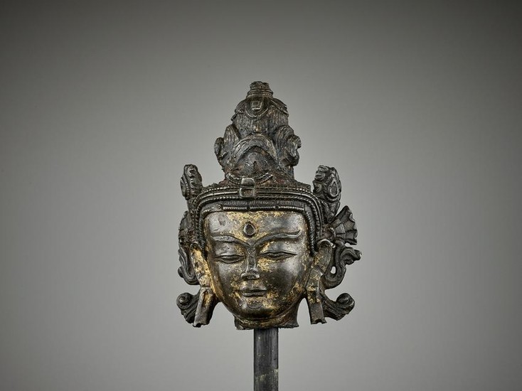 A TIBETAN LACQUER-GILT BRONZE HEAD 14TH CENTURY