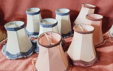 A collection of 8 small clip on lamp shades in blue and pink...