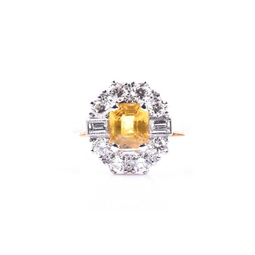 A diamond and yellow sapphire cluster ring, set with a mixed...