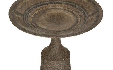 A modern pottery vessel, in the manner of Hans Coper, the disk with faint gold highlight to the inner center, with hourglass neck atop a cylindrical base, indistinctly signed to the underside, 13cm high